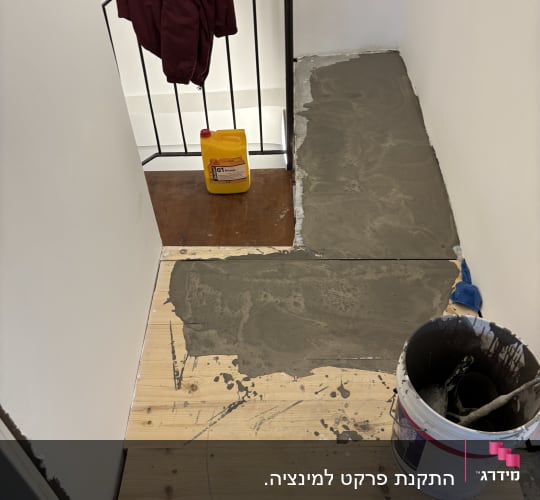 עבודת ריצוף עם דלי וחומרי בנייה